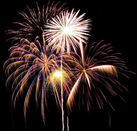 Gold and white Mad Bomber fireworks bursting in the night sky